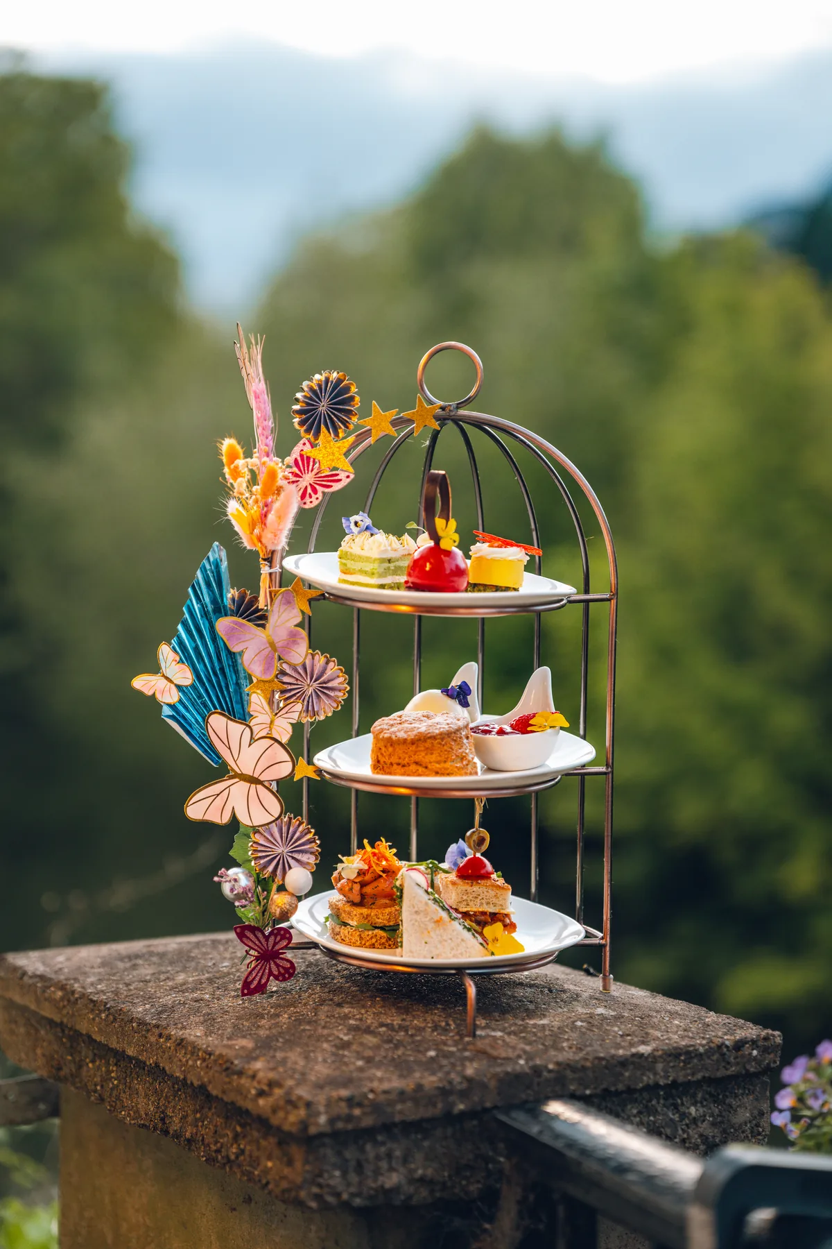 Afternoon tea served outdoors with a garden view at The Terrace