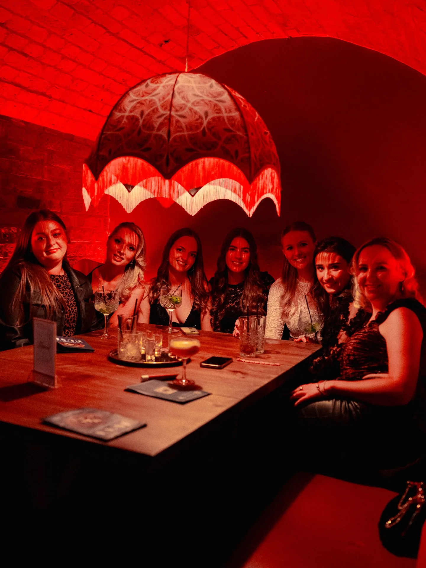 A group of friends celebrating together downstairs at The Truth, The Terrace